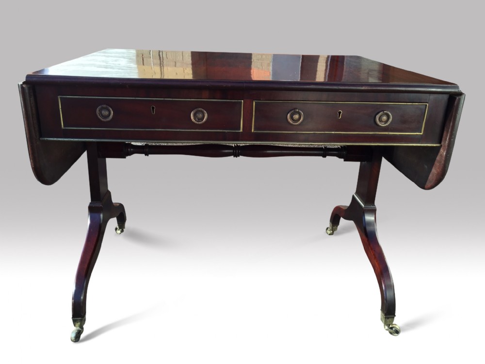 a superb regency mahogany and brass moulded sofa table